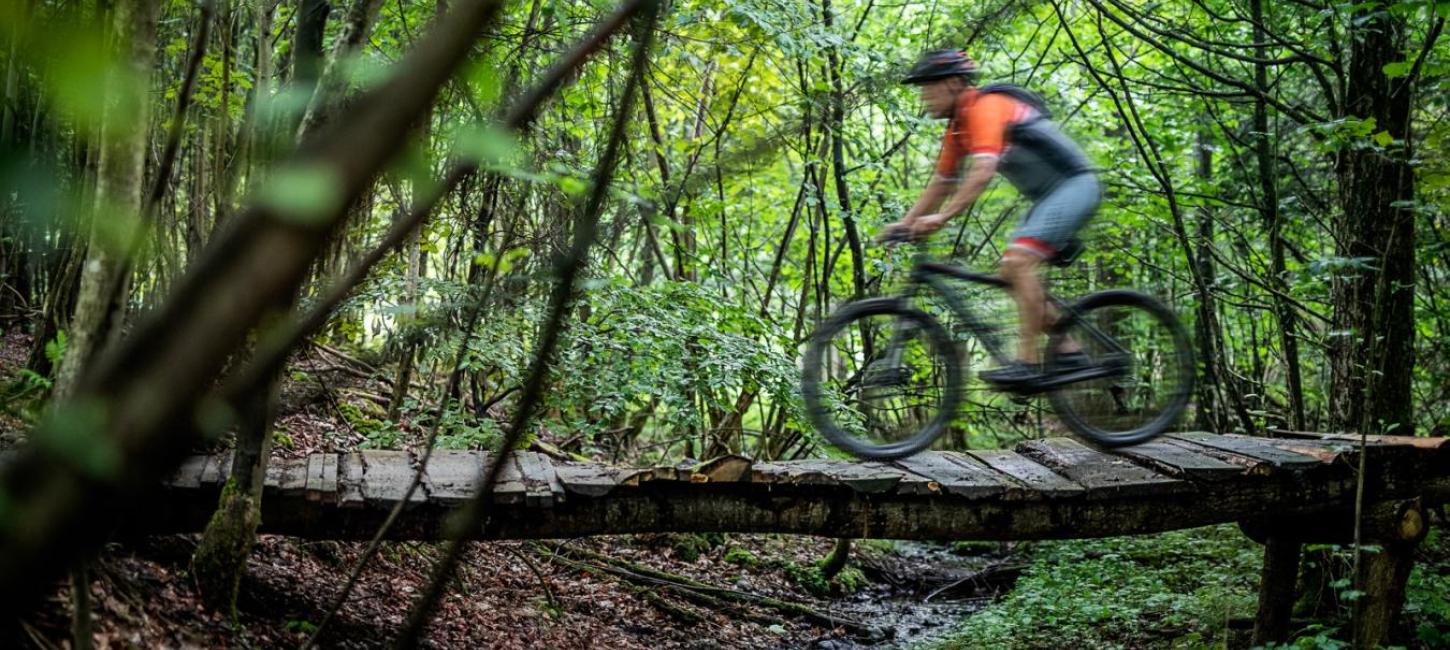 Man riding over a bridge on a mountain bike in Odder