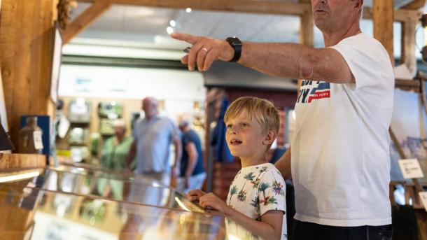A boy and his father looking at a ship exhibit at Juelsminde Harbour Museum