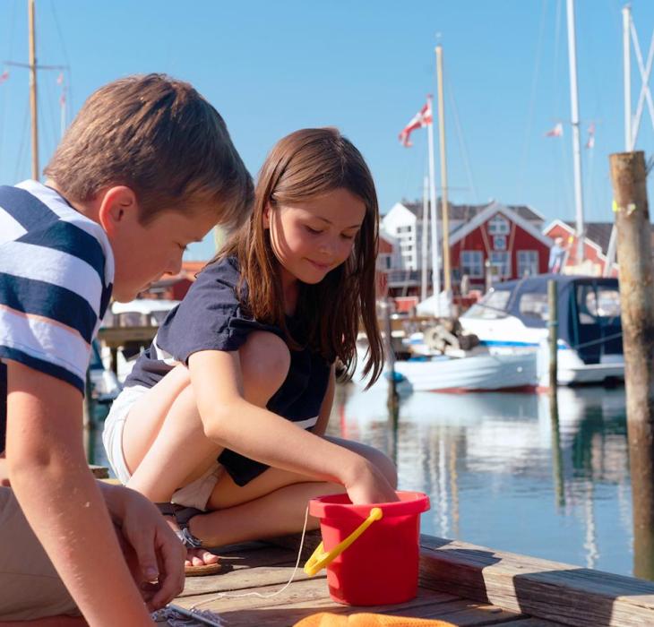 Kids with a red bucket on the marina in Juelsminde